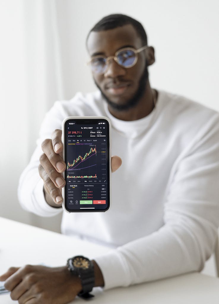 Businessman showing stock graph on smartphone, symbolizing market trends.